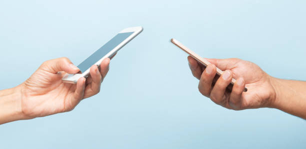 istock Two Hands Holding Mobile Phones 2165496328