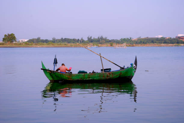 Banjarmasin, Kalimantan - Indonesia – 30 October 2022: everyday in the morning, women in floating market lok baintan, Banjarmasin city, Indonesia paddled their boat to carry out buying and selling various basic needs such as vegetables and crops from villages along martapura river.