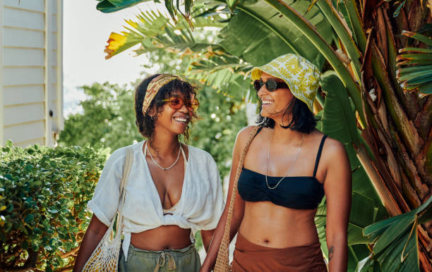 istock Young women laughing while leaving home for a day at the beach 2165497063