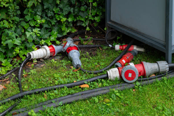 istock Electrical connectors and cables lie on the grass near a construction panel 2165505167