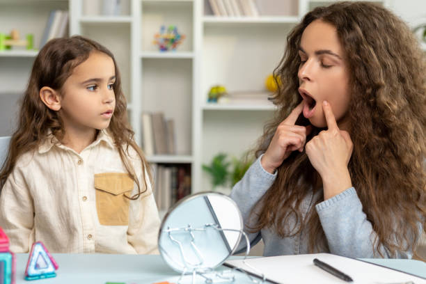 istock Female speech therapist working with a girl on her articulation 2165510181