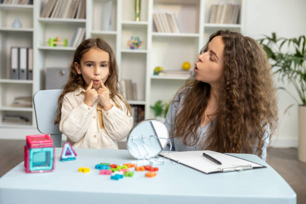 istock Female speech therapist working with a girl on her articulation 2165510184