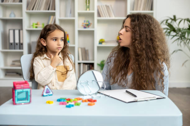 istock Female speech therapist working with a girl on her articulation 2165510203