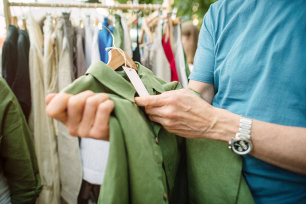 älterer mann, der auf einem lokalen oder flohmarkt einkauft. nachhaltiger lebensstil und zero waste konzept. - tragen stock-fotos und bilder