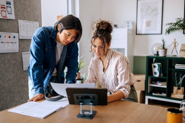 istock Two casually clothed young colleagues cooperating at the modern office 2165512433