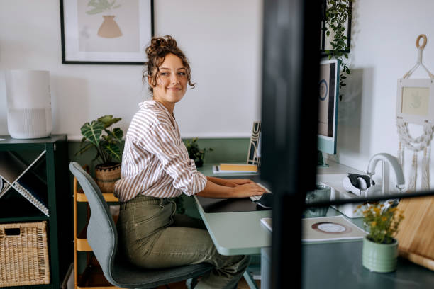 istock Young casually clothed businesswoman using desktop PC at the modern office 2165512463