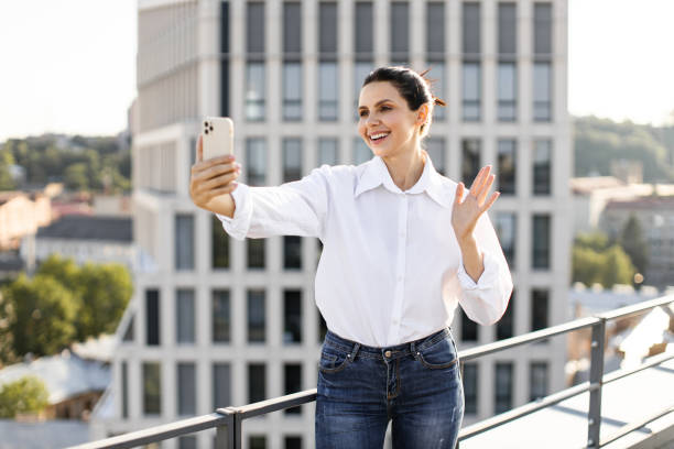 istock Woman taking selfie with smartphone on urban rooftop 2165512629