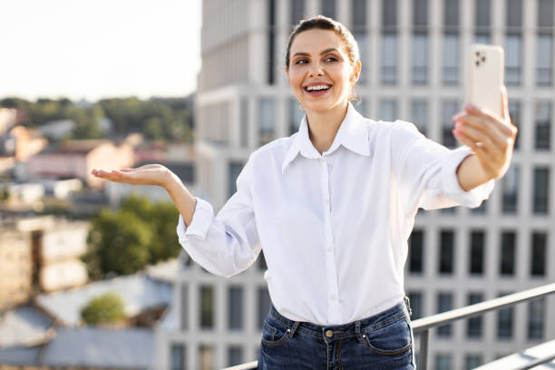 istock Woman taking selfie on rooftop with cityscape background 2165512648