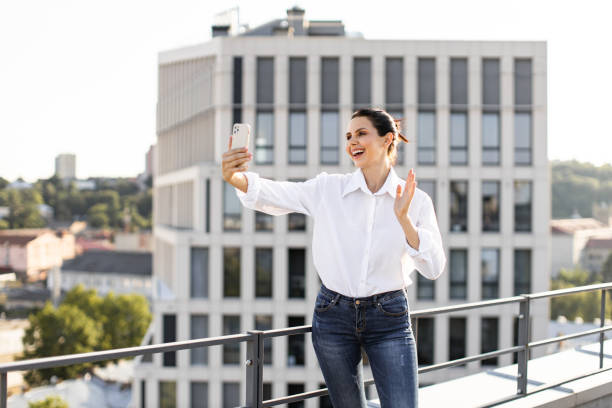Woman taking selfie on rooftop with cityscape background