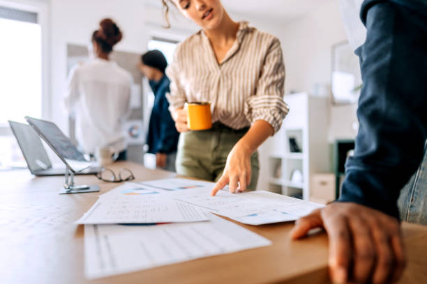 istock Young colleagues going over paperwork at the office 2165512801