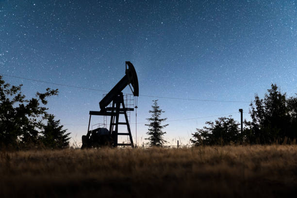 istock Pump jack silhouette on evening field 2165515144