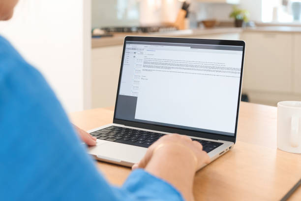 istock Person Working on Laptop at Kitchen Table During Daytime in Cozy Home Environment 2165515865