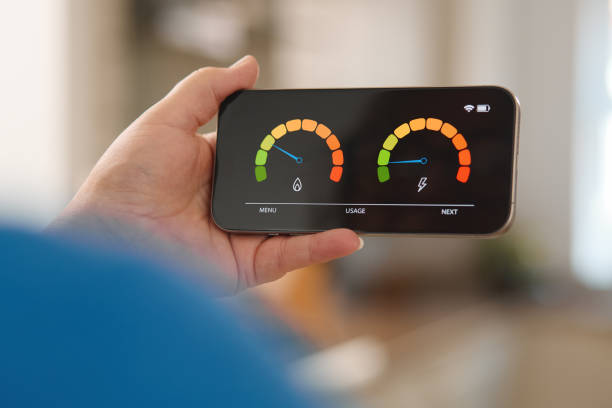 istock Monitoring Energy and Water Usage on a Mobile Device in a Bright Living Room 2165516891