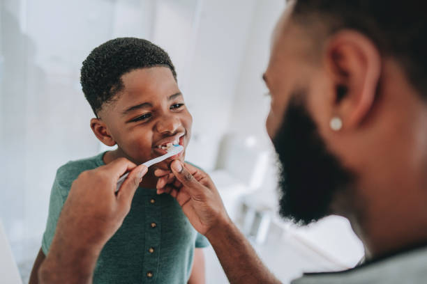 istock Father teaches son how to brush his teeth 2165517224