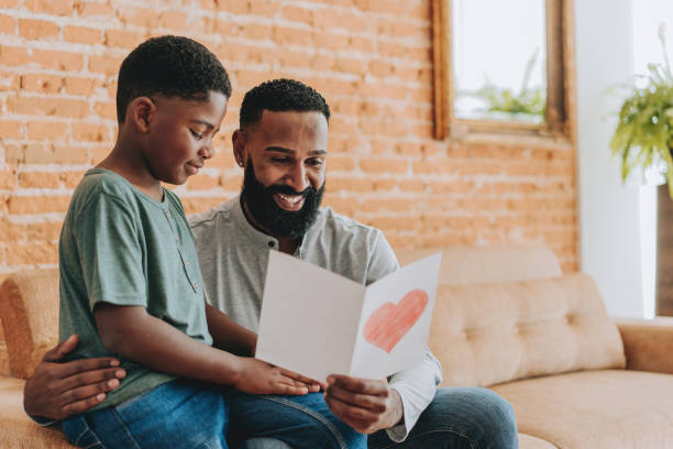 istock Son gives father a postcard on Father's Day 2165517276