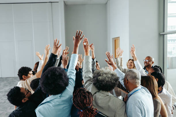 istock Multiethnic team celebrating success with hands raised in a group high-five 2165519651