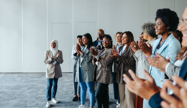istock Diverse conference crowd clapping and smiling in a meeting room 2165520594