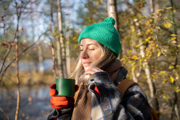 istock Recreating in pine forest middle-aged woman enjoying hot tea drinking while resting after hiking 2165520620