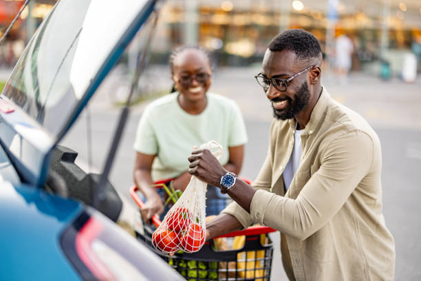 istock Smiling Black Couple Unloading Groceries by Car 2165522177