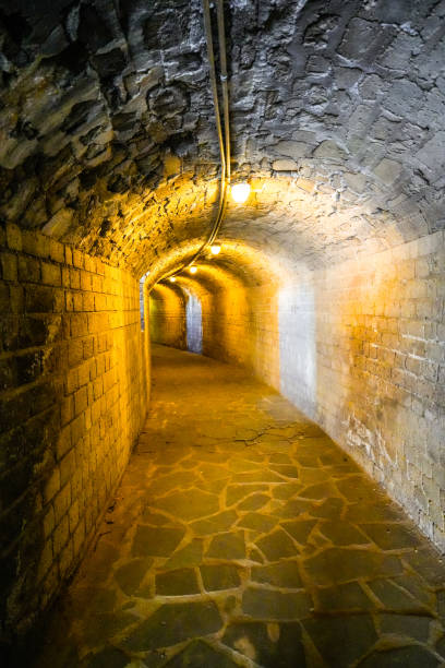istock Old passage in a cellar vault, illuminated with warm light. 2165524866