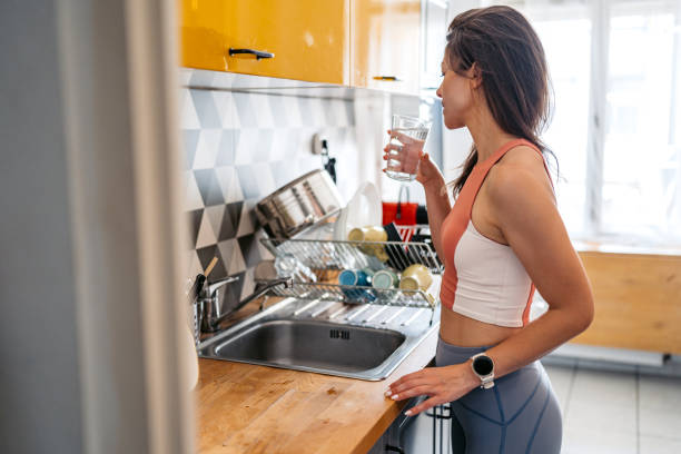 istock Young Woman Drinking Water After Exercising At Home 2165528462