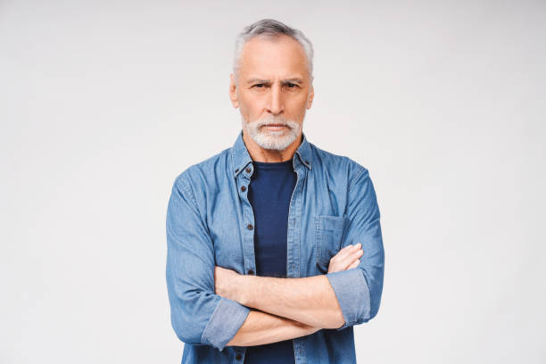 istock Smiling mature gray-haired man with arms folded over white background. Advertisement concept 2165528539