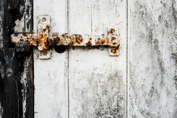 istock Close-up of a rusty metal latch seen on flacking paint. 2165529431