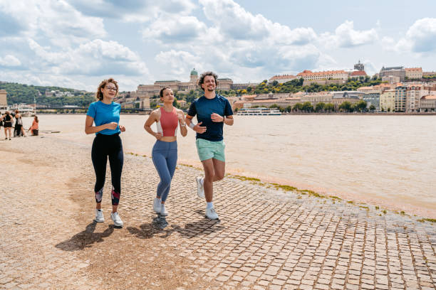 istock Three Friends Running On The Quayside In Budapest In Hungary 2165529535