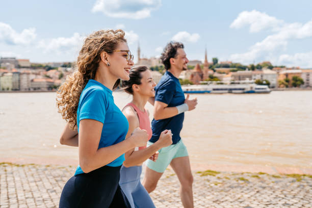 Three Friends Running On The Quayside In Budapest In Hungary