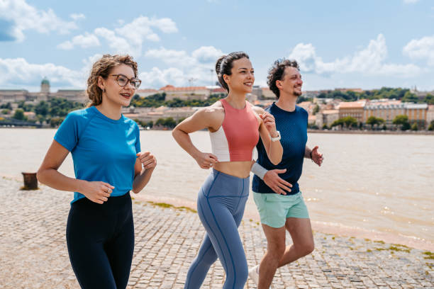 istock Three Friends Running On The Quayside In Budapest In Hungary 2165529571