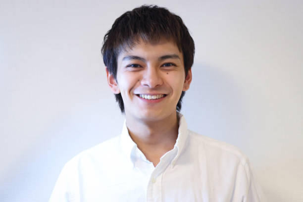 Handsome Young man wearing a white shirt and smiling white bachground.