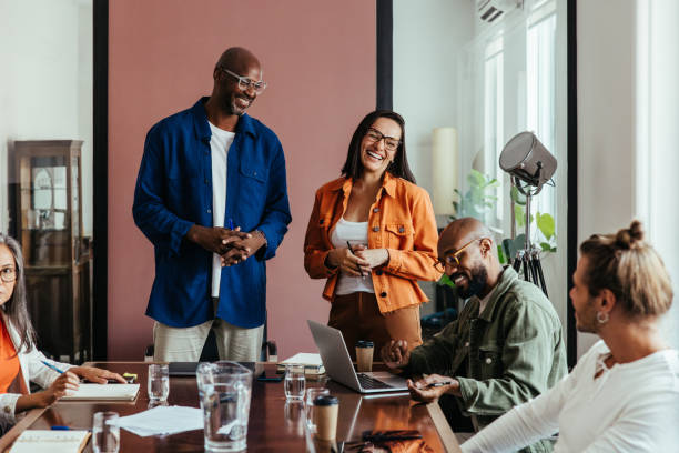 istock Creatives collaborating and laughing in a relaxed modern boardroom meeting 2165532726