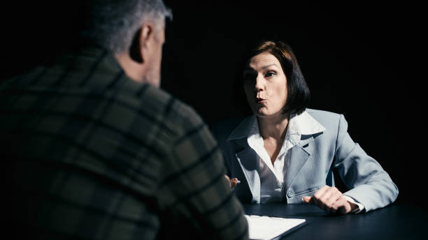 istock Police detective persuading a man in custody to sign a confession, interrogation 2165533407