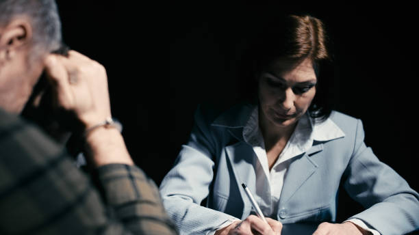istock Attorney questioning her client in handcuffs in an interrogation room, writing down answers 2165533450