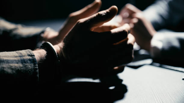 istock Arrested man with his hands in handcuffs talking to a detective, close-up 2165533461