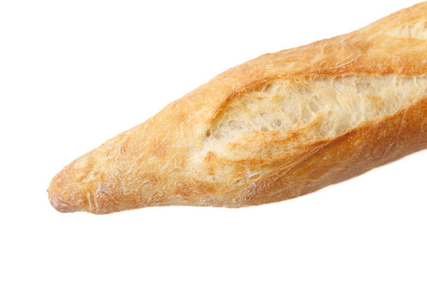 Long loaf of crusty bread resting against a vibrant blue sky with white clouds.