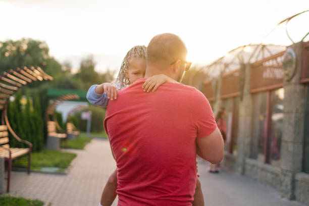 istock Father comforts little crying daughter holding her in arms and gently hugging 2165535454
