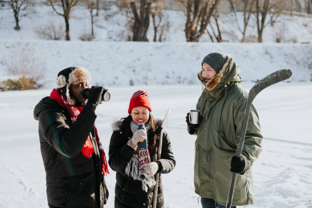 Multi-ethnic friends drinking tea and having a chat after a winter day spent together outdoors