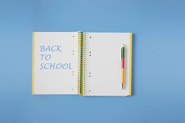 istock Back to school concept, open notebook and colour pen on blue background 2165538591