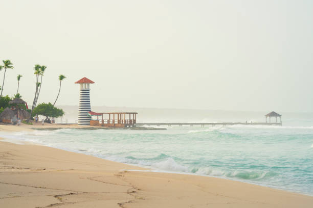 Bayahibe beach at morning, heavy sea and beautiful lighthouse with pier.Dominican republic.
