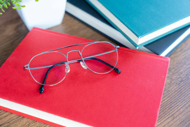 Eyeglasses resting on a stack of books, representing the concept of reading
