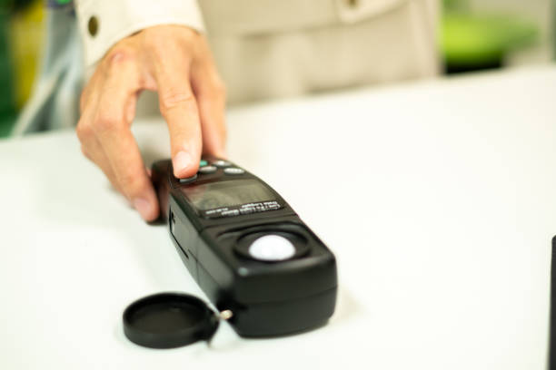 An electrical worker's hand is holding a light meter in the workplace, lighting, light meter, occupational safety, occupational health, office electric light