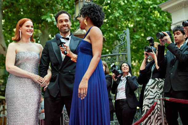 istock Celebrity couple interviewed outdoors at red carpet event 2165541243