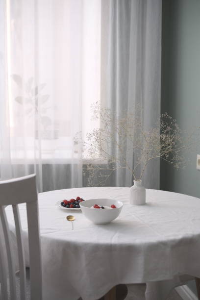 istock Elegant dining table with white decor, berries, and flowers, creating an inviting atmosphere 2165542864