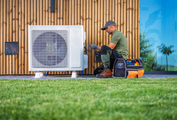 istock Technician Performing Maintenance on Air Conditioning Unit in Residential Garden During Daytime 2165544767