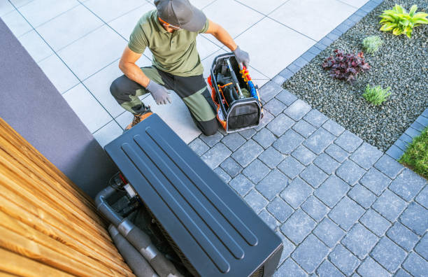 Technician Working on Outdoor HVAC Unit in Residential Area During Daylight