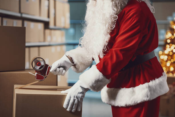 istock Santa Claus taping a delivery box at the warehouse 2165545314