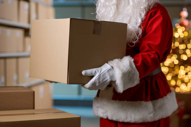 istock Santa Claus holding a box at the distribution warehouse 2165545405