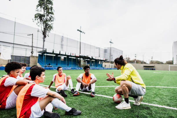 istock Coach talking with soccer players during training on soccer field 2165547026