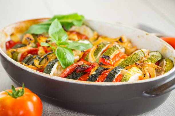 istock prepared baked zucchini and tomatoes in circles in a ceramic form, vegetable snack 2165547474